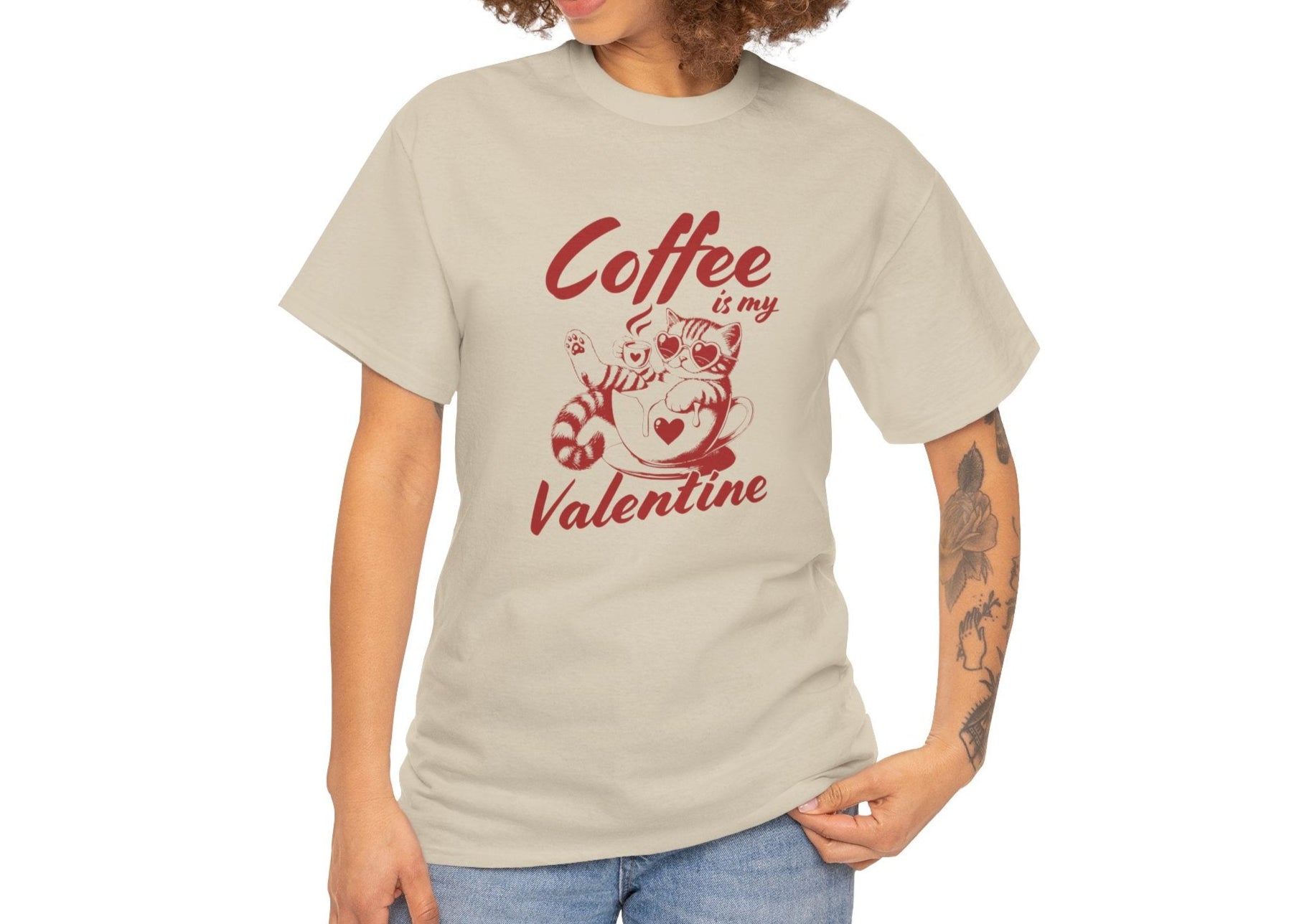 Woman with curly hair wearing a beige T-shirt with red text and cat illustration holding a coffee cup that reads "Coffee Is My Valentine." Exclusive release for Valentine’s Day. Part of the Vivid Divergence Sensory Friendly Unisex Tees Range.