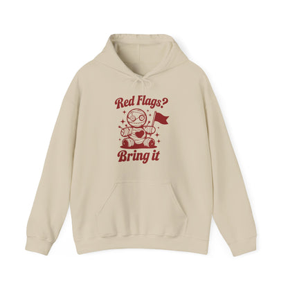 Front view of a beige hoodie featuring "Red Flags? Bring It" text and a cute voodoo doll holding a red flag. Exclusive release for Valentine's Day. Part of the Vivid Divergence Sensory Friendly Sweaters Range.