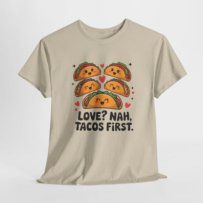 Hanging beige T-shirt featuring an illustration of tacos and black text that reads "Love? Nah, Tacos First." Exclusive release for Valentine’s Day. Part of the Vivid Divergence Sensory Friendly Unisex Tees Range.