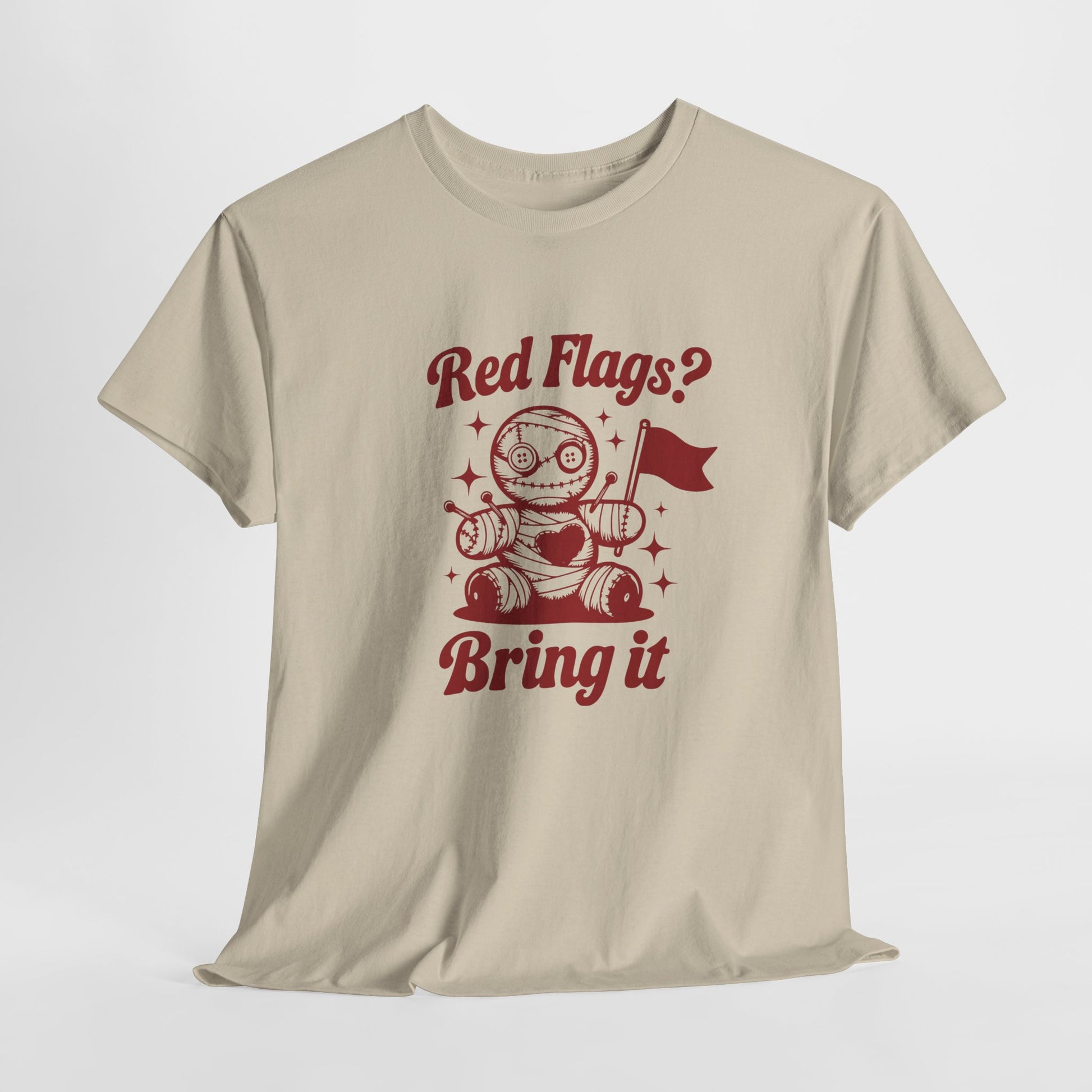 Hanging view of a beige T-shirt featuring the "Red Flags? Bring It" design with a cute voodoo doll holding a red flag surrounded by sparkles. Part of the Vivid Divergence Sensory Friendly Unisex Tees Range.