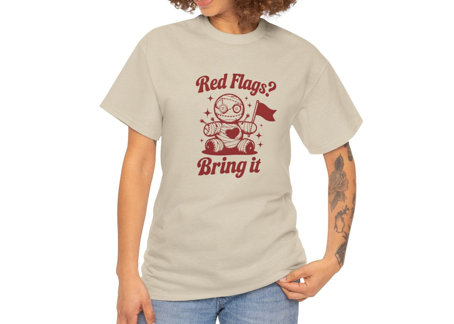 Modeled view of a beige T-shirt featuring the "Red Flags? Bring It" design with a cute voodoo doll holding a red flag surrounded by sparkles. Part of the Vivid Divergence Sensory Friendly Unisex Tees Range.