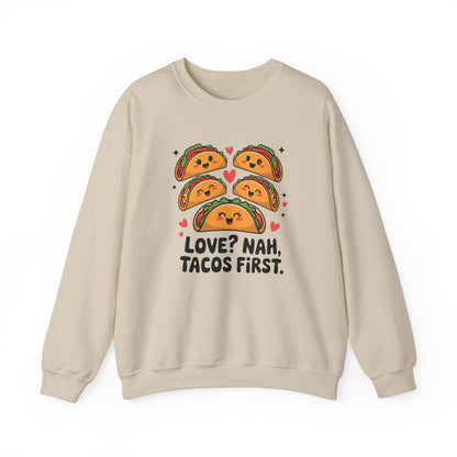 Front view of a beige sweatshirt with "Love? Nah. Tacos First." text and cute taco characters design in orange and brown. Exclusive release for Valentine's Day. Part of the Vivid Divergence Sensory Friendly Sweaters Range.