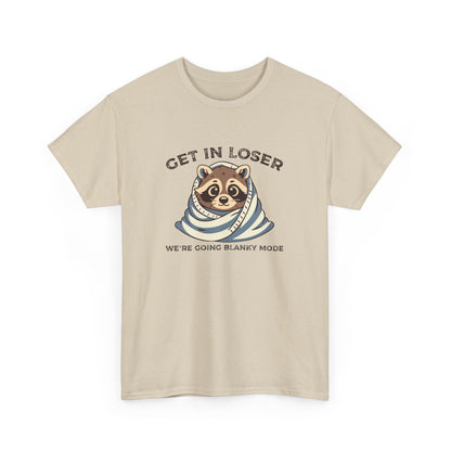 Hanging front view of a beige T-shirt featuring a cute raccoon wrapped in a blanket with text that reads "Get In Loser, We're Going Blanky Mode." Part of the Vivid Divergence Sensory Friendly Unisex Tees Range.