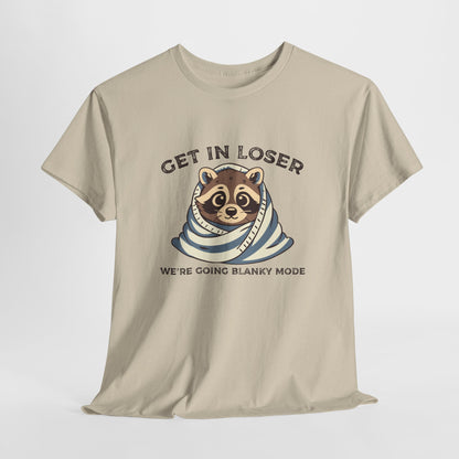 Hanging front view of a beige T-shirt featuring a cute raccoon wrapped in a blanket with text that reads "Get In Loser, We're Going Blanky Mode." Part of the Vivid Divergence Sensory Friendly Unisex Tees Range.