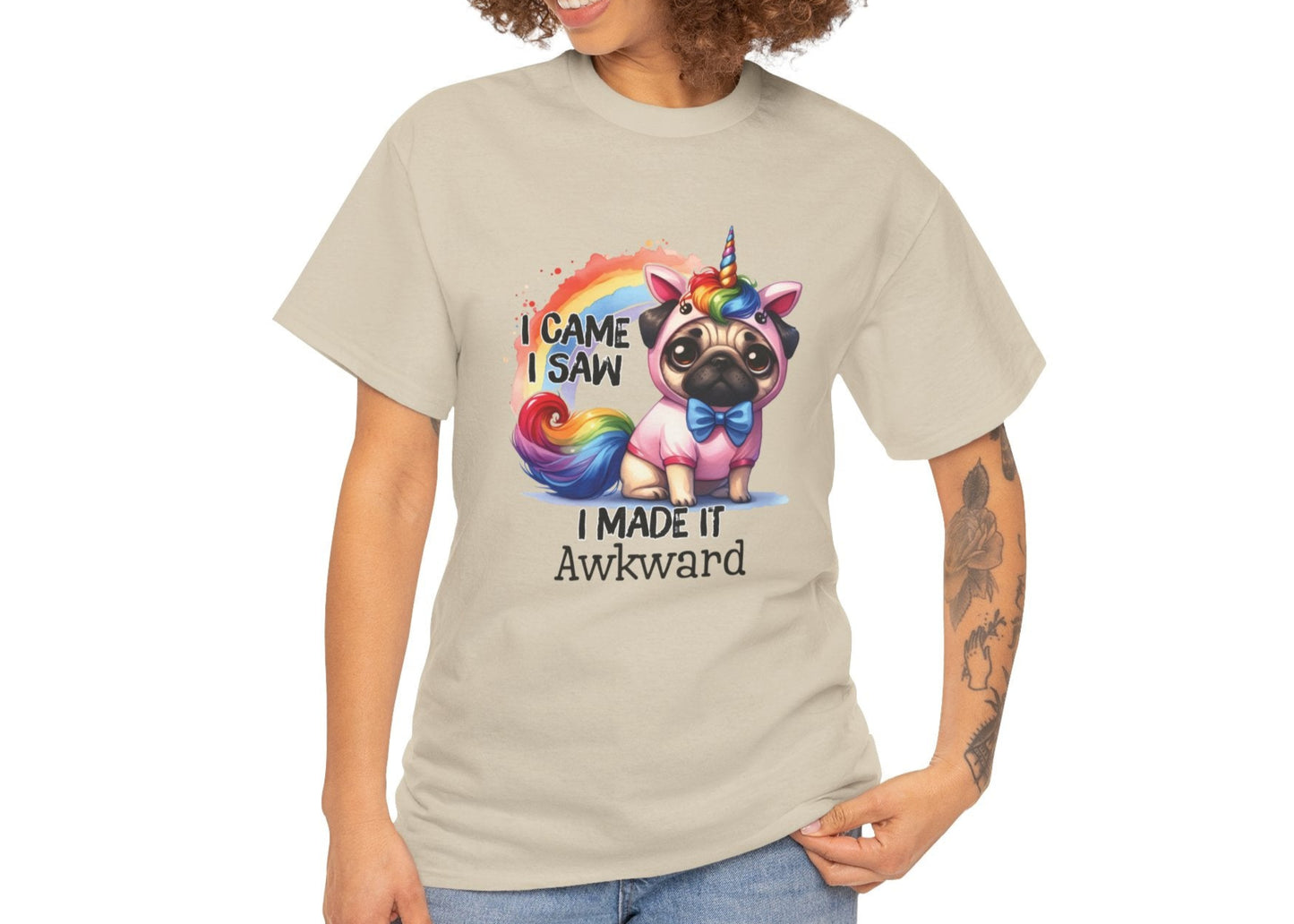 Woman with curly hair wearing a beige T-shirt featuring a colorful unicorn pug design with the text "I Came, I Saw, I Made It Awkward." Part of the Vivid Divergence Sensory Friendly Unisex Tees Range.