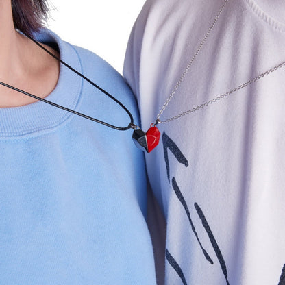 Two people wearing red and black best friend necklaces for couples, magnetically connected to form a heart shape.