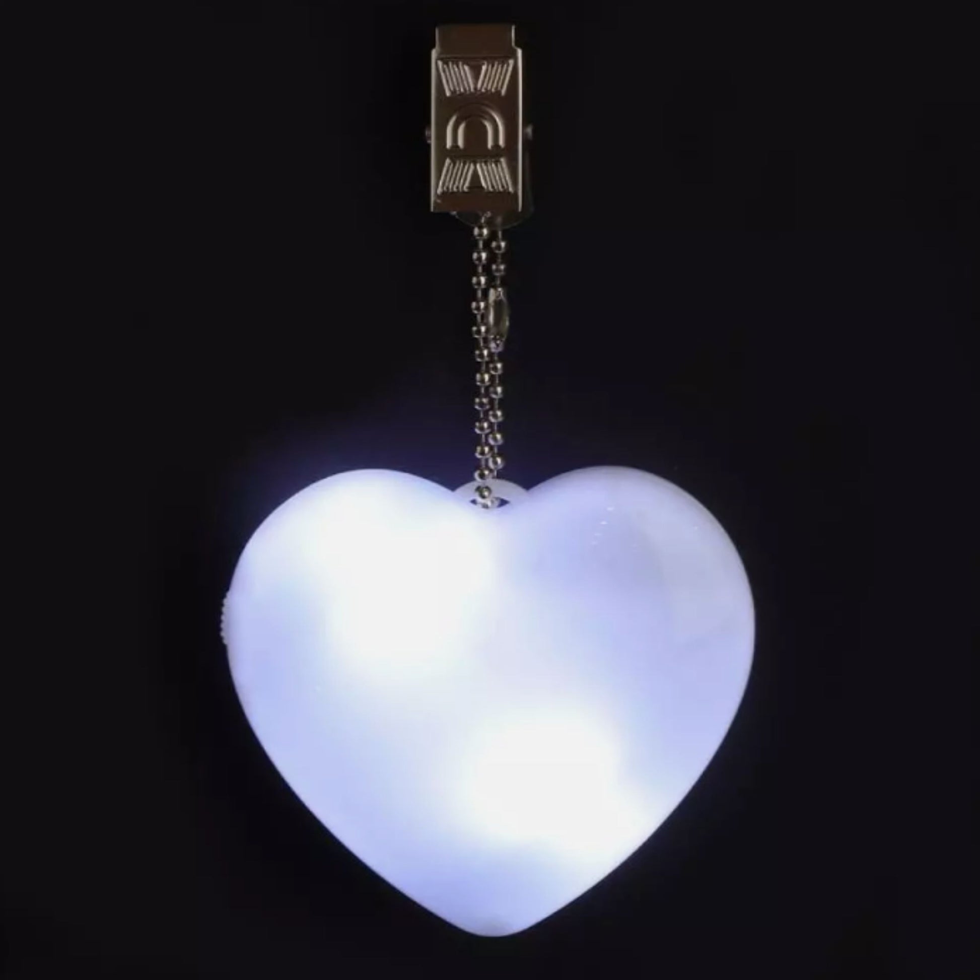 Glowing heart-shaped LED bag clip against a dark background, demonstrating its bright LED light for low-light environments.