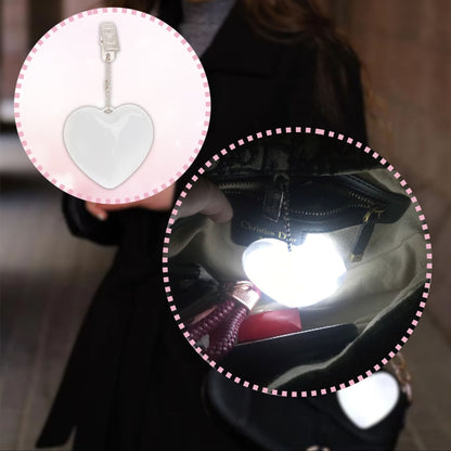 Close-up of a heart-shaped LED bag clip highlighting its glowing LED light and portable design for easy use.