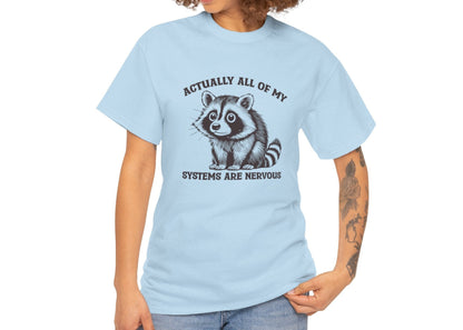 Model wearing a light blue T-shirt with "Actually All Of My Systems Are Nervous" text and a raccoon graphic. Part of the Vivid Divergence Sensory Friendly Unisex Tees Range.
