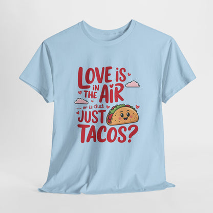 Hanging light blue T-shirt featuring red and black text with a taco illustration that reads "Love Is In The Air Or Is It Just Tacos?" Exclusive release for Valentine’s Day. Part of the Vivid Divergence Sensory Friendly Unisex Tees Range.