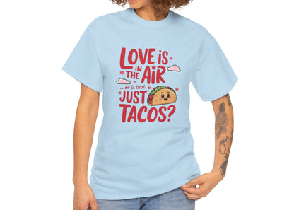 Woman wearing a light blue T-shirt featuring red and black text with a taco illustration that reads "Love Is In The Air Or Is It Just Tacos?" Exclusive release for Valentine’s Day. Part of the Vivid Divergence Sensory Friendly Unisex Tees Range.