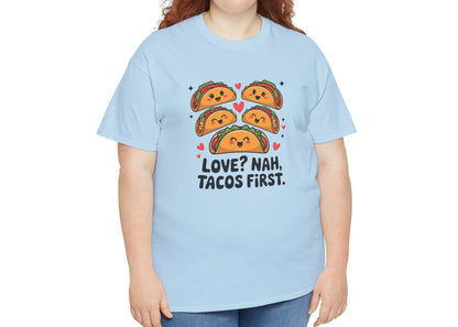 Front view of a light blue T-shirt worn by a woman, featuring an illustration of tacos and black text that reads "Love? Nah, Tacos First." Exclusive release for Valentine’s Day. Part of the Vivid Divergence Sensory Friendly Unisex Tees Range.