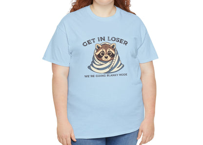 Modeled front view of a light blue T-shirt featuring a cute raccoon wrapped in a blanket with text that reads "Get In Loser, We're Going Blanky Mode." Part of the Vivid Divergence Sensory Friendly Unisex Tees Range.