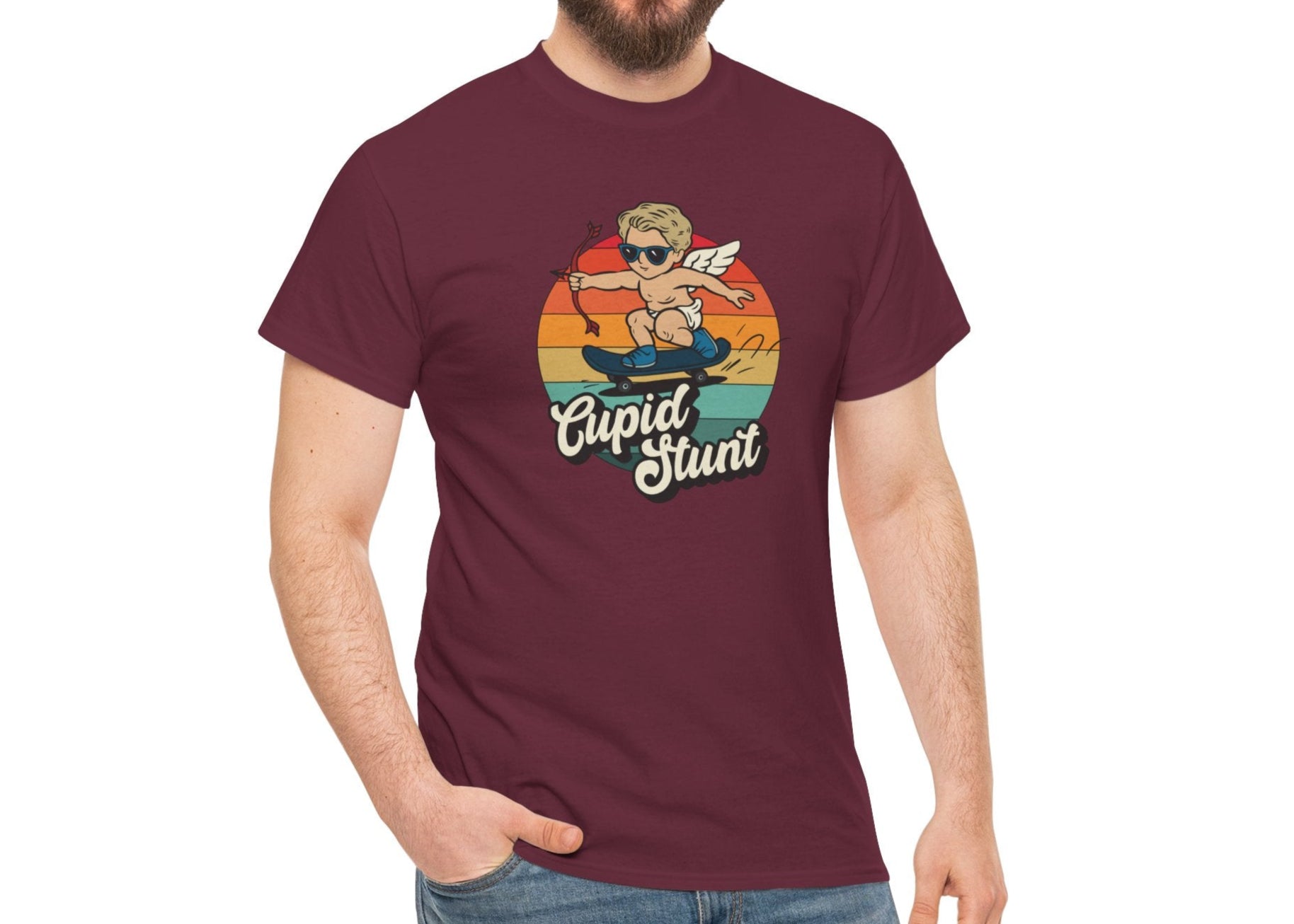 Man wearing a maroon T-shirt featuring a retro sunset background and a cartoon cupid with the text "Cupid Stunt." Exclusive release for Valentine’s Day. Part of the Vivid Divergence Sensory Friendly Unisex Tees Range.