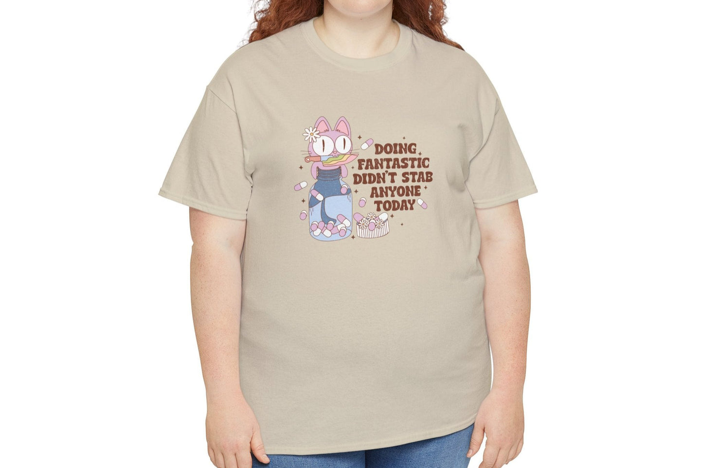 Model wearing a beige T-shirt with a cartoon character and the text "Doing Fantastic, Didn't Stab Anyone Today." Part of the Vivid Divergence Sensory Friendly Unisex Tees Range.