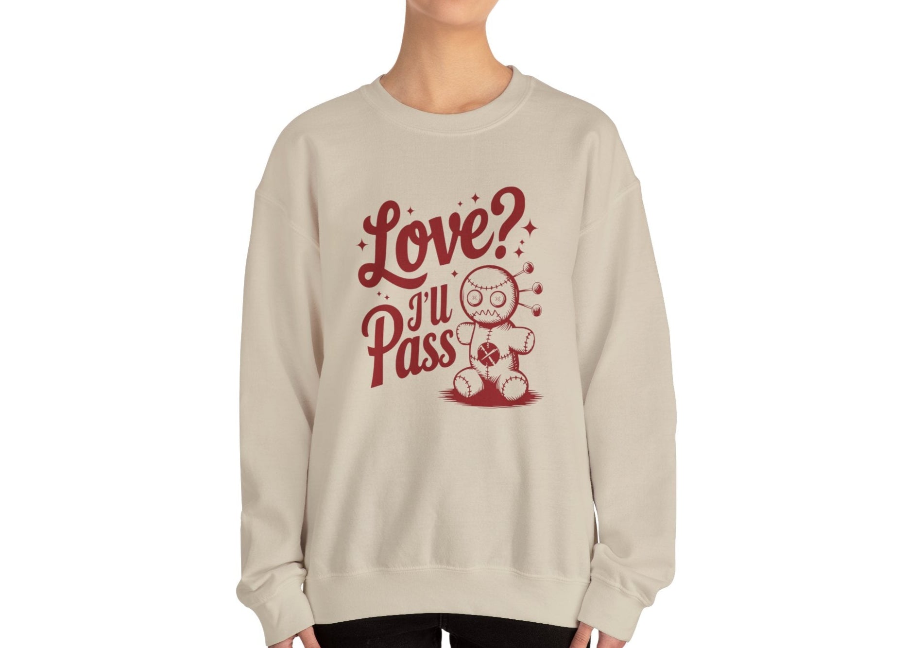 Model wearing a beige sweatshirt with "Love? I'll Pass" text and a cute voodoo doll design in red. Exclusive release for Valentine's Day. Part of the Vivid Divergence Sensory Friendly Sweaters Range.