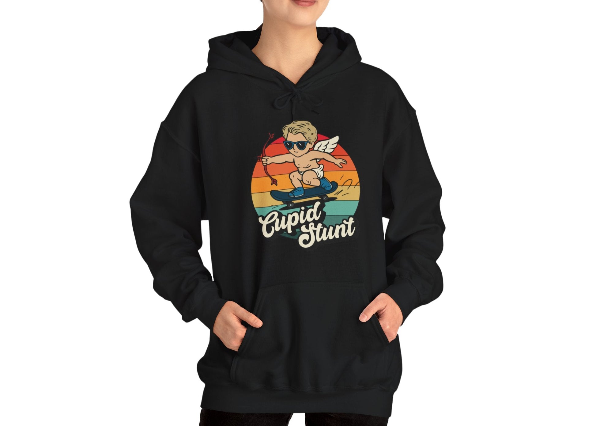 Model wearing a black hoodie with a vintage sunset design featuring Cupid riding a skateboard and "Cupid Stunt" text. Exclusive release for Valentine's Day. Part of the Vivid Divergence Sensory Friendly Sweaters Range.