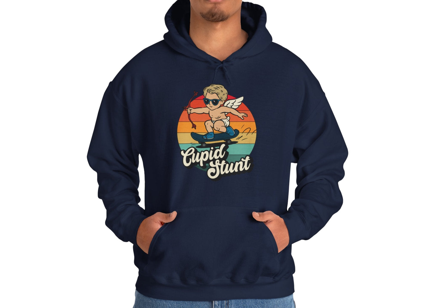 Model wearing a navy hoodie with a vintage sunset design featuring Cupid riding a skateboard and "Cupid Stunt" text. Exclusive release for Valentine's Day. Part of the Vivid Divergence Sensory Friendly Sweaters Range.