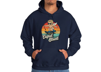 Model wearing a navy hoodie with a vintage sunset design featuring Cupid riding a skateboard and "Cupid Stunt" text. Exclusive release for Valentine's Day. Part of the Vivid Divergence Sensory Friendly Sweaters Range.