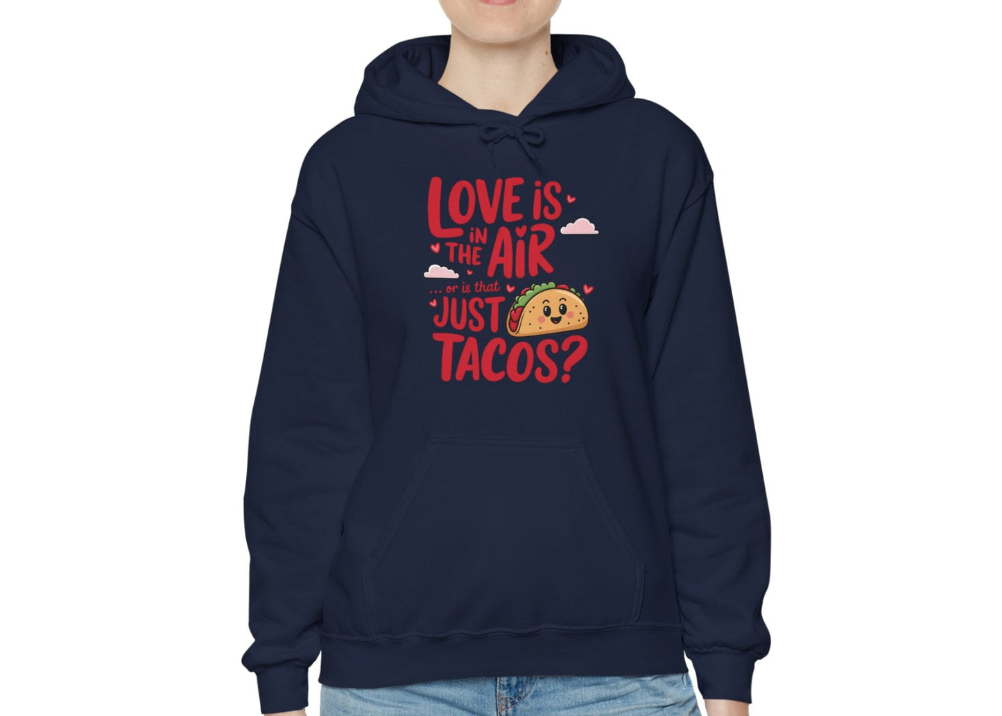 Model wearing a navy hoodie with "Love Is in the Air or Is It Just Tacos?" text and a cute taco graphic in red and yellow. Exclusive release for Valentine's Day. Part of the Vivid Divergence Sensory Friendly Sweaters Range.