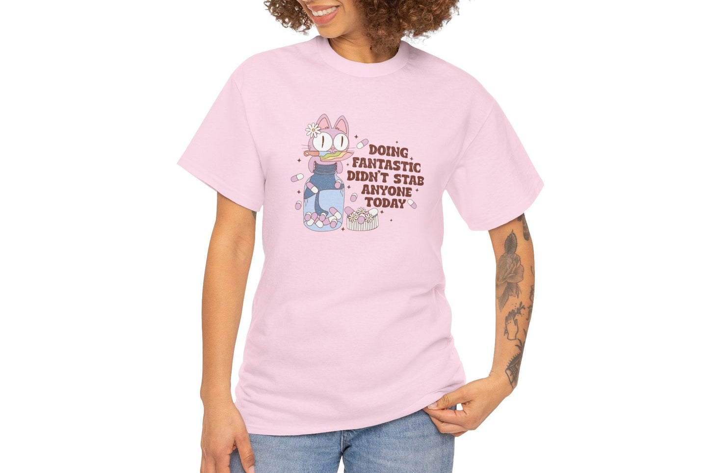 Model wearing a pink T-shirt with a cartoon character and the text "Doing Fantastic, Didn't Stab Anyone Today." Part of the Vivid Divergence Sensory Friendly Unisex Tees Range.