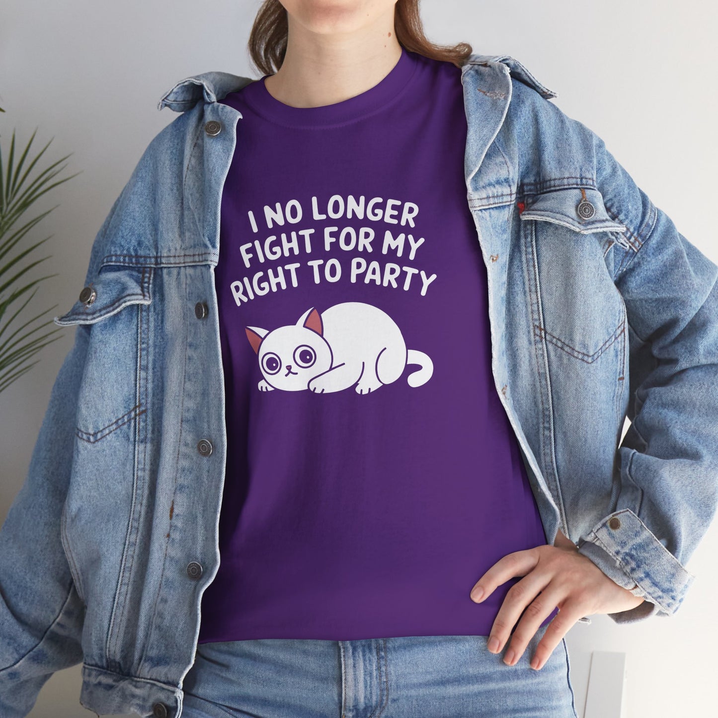 Model wearing a purple T-shirt with the text "I No Longer Fight For My Right To Party" above a napping white cat graphic, posing with a denim jacket. Part of the Vivid Divergence Sensory Friendly Unisex Tees Range.