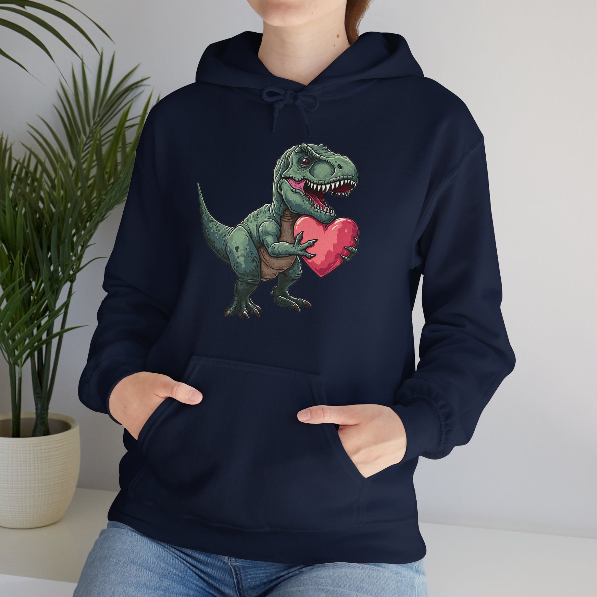 Model wearing a navy hoodie featuring a cute cartoon T-Rex holding a pink heart while seated. Exclusive release for Valentine's Day. Part of the Vivid Divergence Sensory Friendly Sweaters Range.