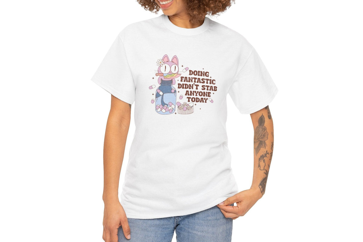 Model wearing a white T-shirt with a cartoon character and the text "Doing Fantastic, Didn't Stab Anyone Today." Part of the Vivid Divergence Sensory Friendly Unisex Tees Range. 