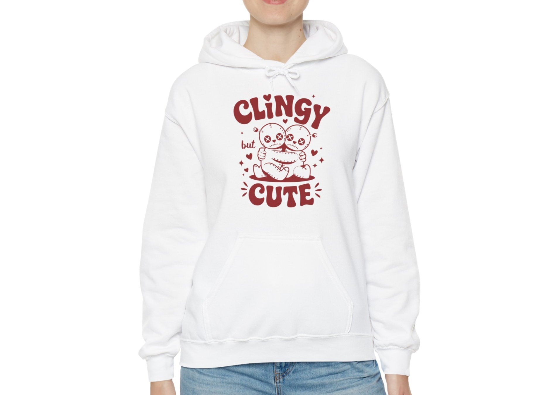 Model wearing a white hoodie with "Clingy but Cute" text and a cute voodoo doll design in red. Exclusive release for Valentine's Day. Part of the Vivid Divergence Sensory Friendly Sweaters Range.