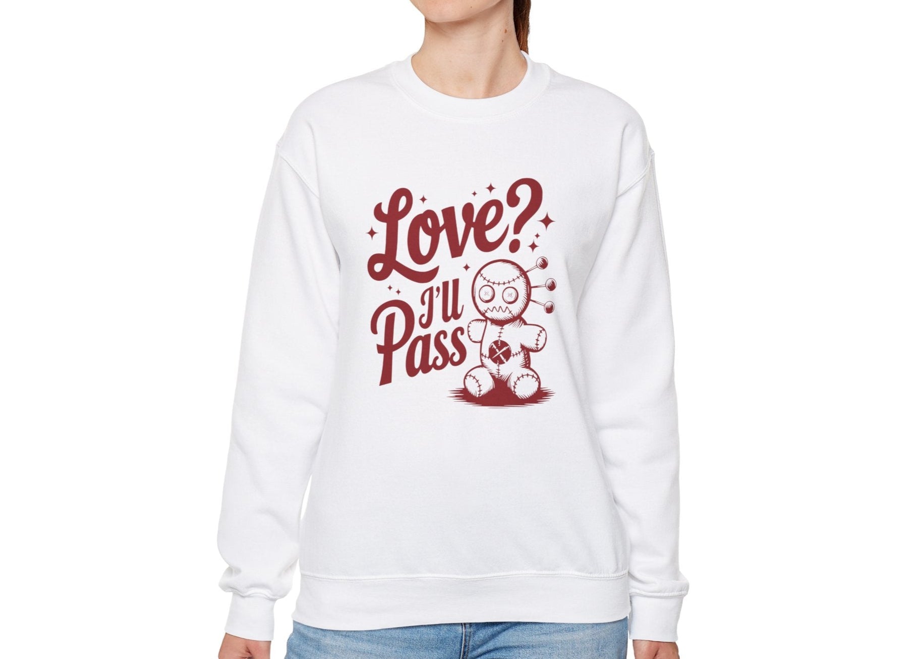 Model wearing a white sweatshirt with "Love? I'll Pass" text and a cute voodoo doll design in red. Exclusive release for Valentine's Day. Part of the Vivid Divergence Sensory Friendly Sweaters Range.