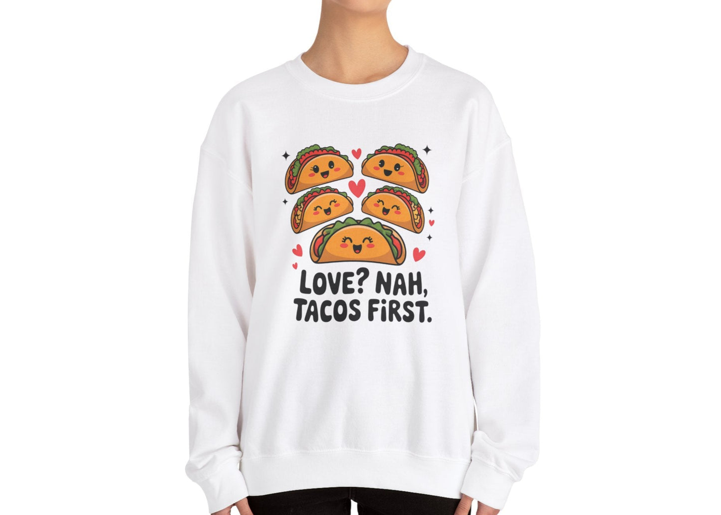 Model wearing a white sweatshirt with "Love? Nah. Tacos First." text and cute taco characters design in orange and brown. Exclusive release for Valentine's Day. Part of the Vivid Divergence Sensory Friendly Sweaters Range.