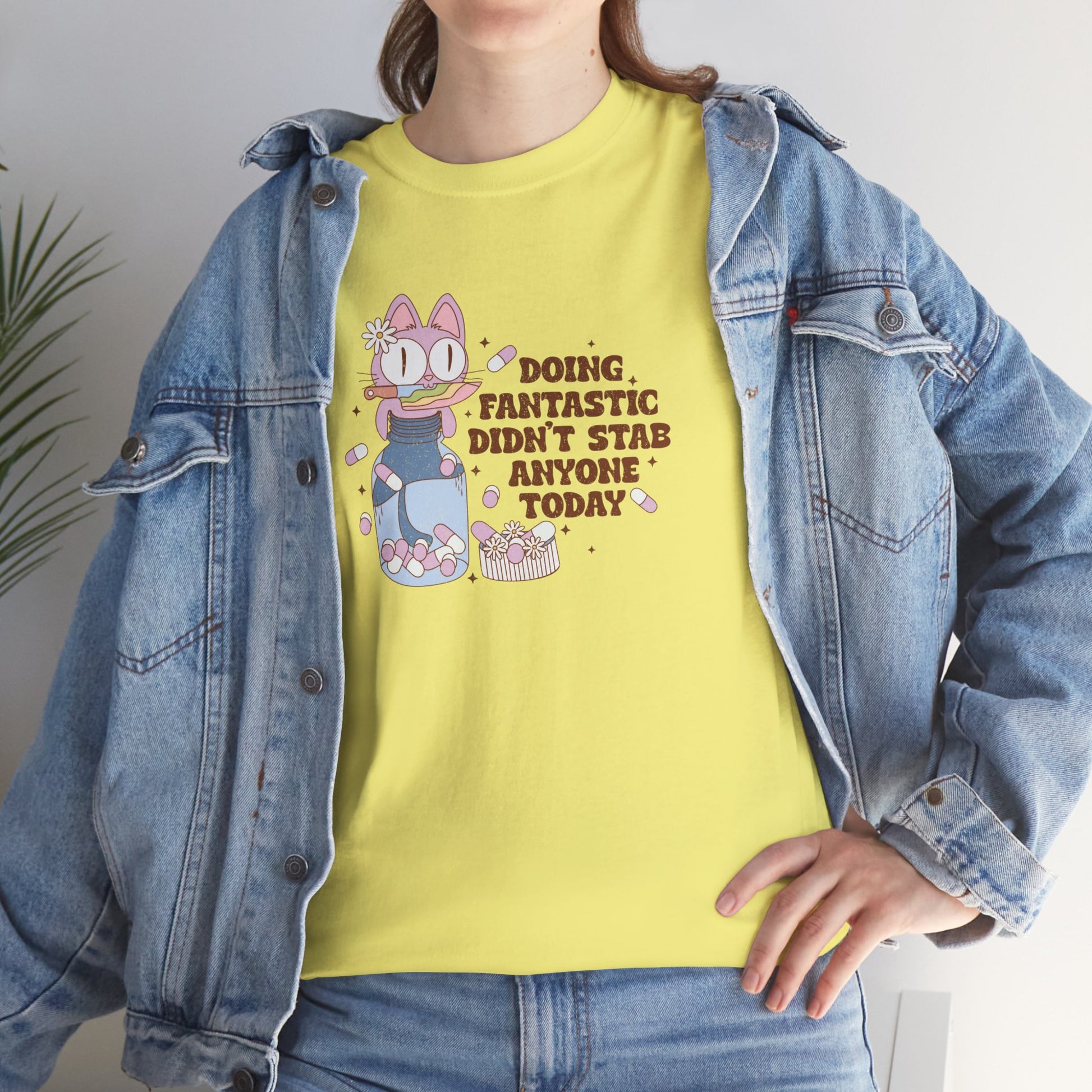 Model wearing a yellow T-shirt with a cartoon character and the text "Doing Fantastic, Didn't Stab Anyone Today." Part of the Vivid Divergence Sensory Friendly Unisex Tees Range.