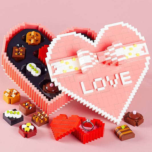 Open pink heart-shaped gift box made of building blocks, featuring miniature chocolate designs inside. Perfect for Valentine’s Day or anniversaries.