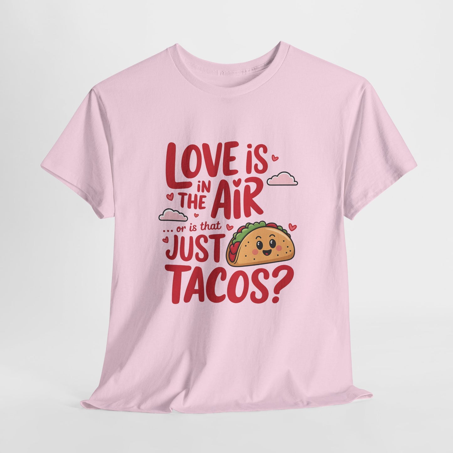 Hanging pink T-shirt featuring red and black text with a taco illustration that reads "Love Is In The Air Or Is It Just Tacos?" Exclusive release for Valentine’s Day. Part of the Vivid Divergence Sensory Friendly Unisex Tees Range.