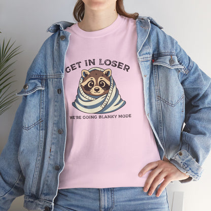 Modeled front view of a pink T-shirt featuring a cute raccoon wrapped in a blanket with text that reads "Get In Loser, We're Going Blanky Mode." Part of the Vivid Divergence Sensory Friendly Unisex Tees Range.