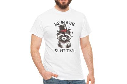 Model wearing a white T-shirt featuring a raccoon with a top hat and the text "Be In Awe Of My Tism," shown from the front. Part of the Vivid Divergence Sensory Friendly Unisex Tees Range.