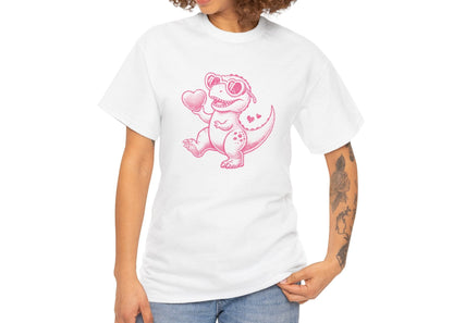 Woman with curly hair wearing a white T-shirt featuring a bright pink cartoon dinosaur holding a heart, designed for Valentine’s Day. Exclusive release for Valentine’s Day. Part of the Vivid Divergence Sensory Friendly Unisex Tees Range.