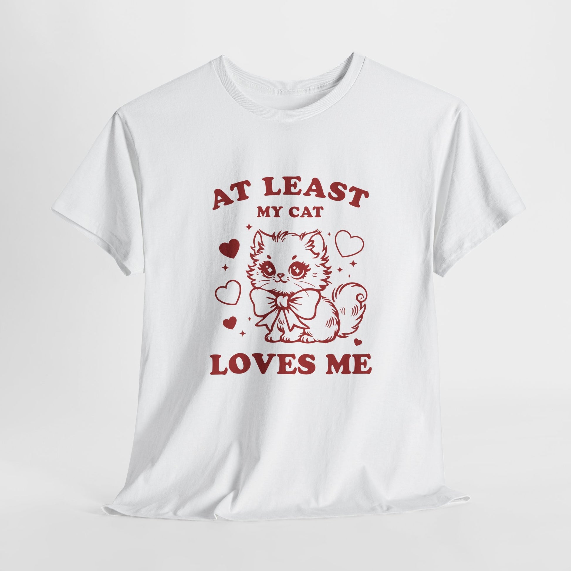 Hanging view of a white T-shirt with red text and cat illustration that reads "At Least My Cat Loves Me." Exclusive release for Valentine’s Day. Part of the Vivid Divergence Sensory Friendly Unisex Tees Range.