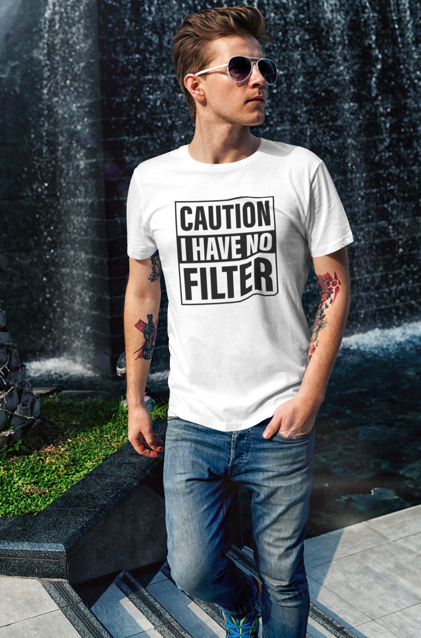 A man wearing a white T-shirt with bold text "Caution: I Have No Filter" in black, standing outdoors. Part of the Vivid Divergence Sensory Friendly Unisex Tees Range.