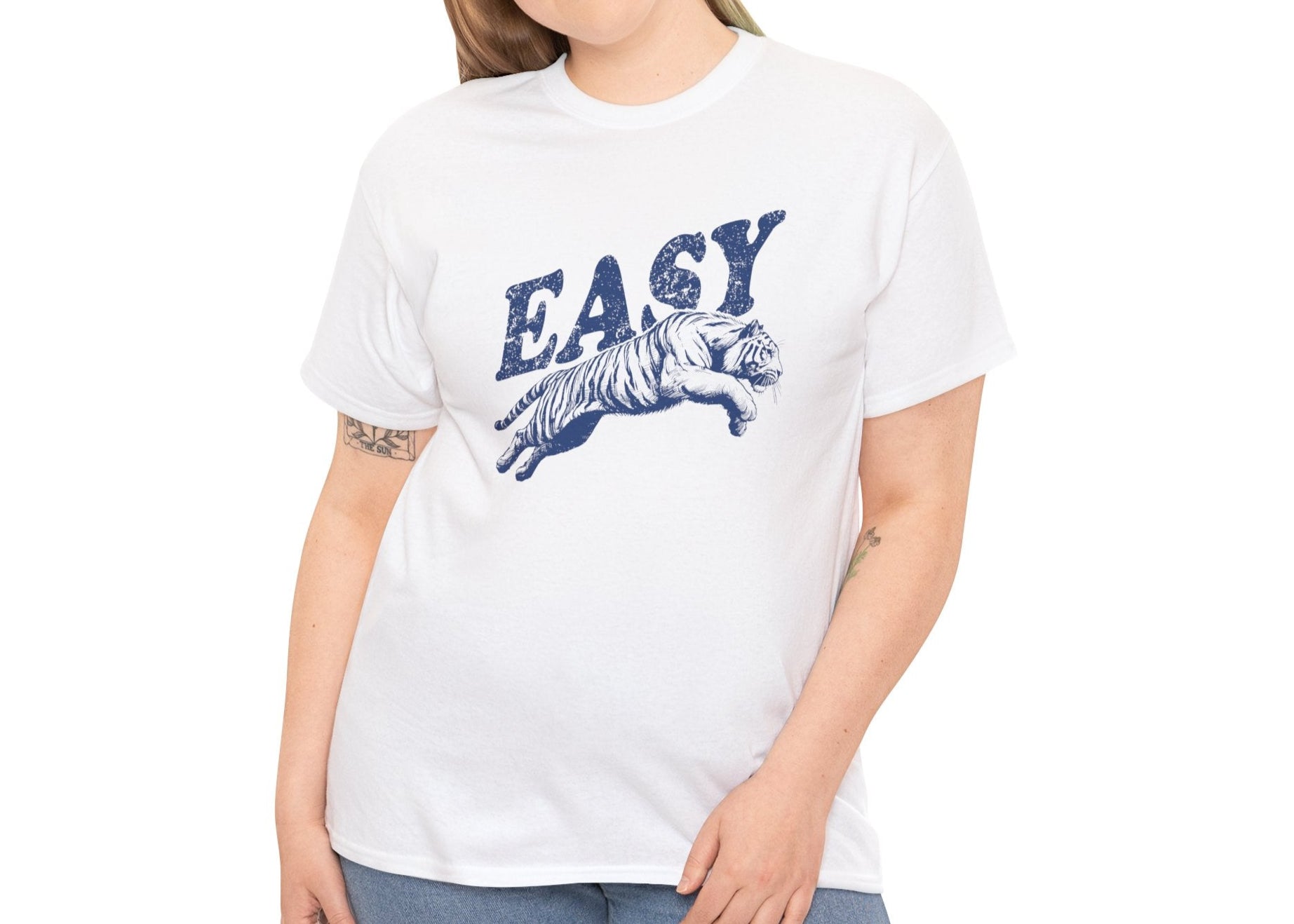 Person wearing a white T-shirt with "EASY" text and tiger illustration in blue, shown from a side angle. Part of the Vivid Divergence Sensory Friendly Unisex Tees Range.