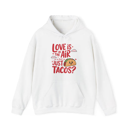 Front view of a white hoodie with "Love Is in the Air or Is It Just Tacos?" text and a cute taco graphic in red and yellow. Exclusive release for Valentine's Day. Part of the Vivid Divergence Sensory Friendly Sweaters Range.