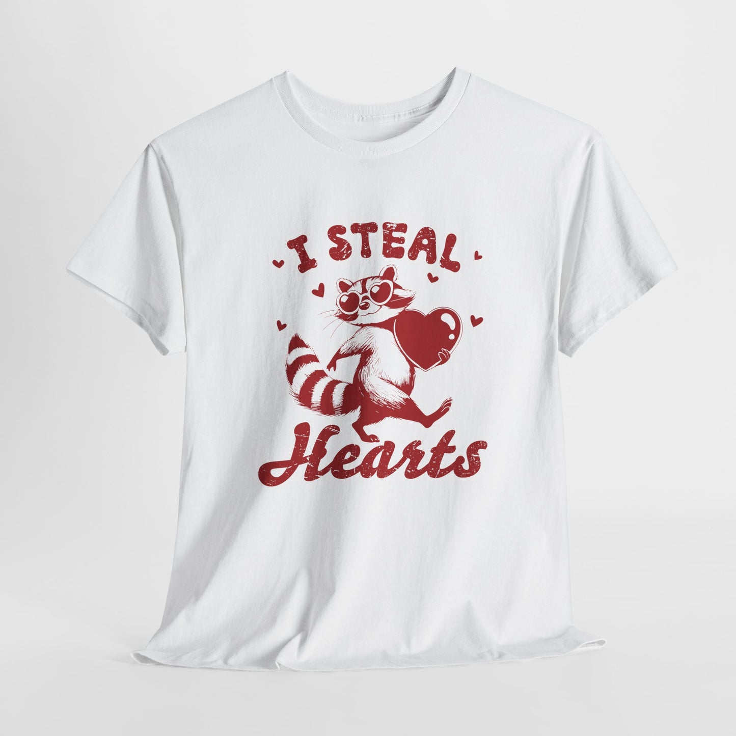 Hanging white T-shirt with red text and raccoon illustration holding a heart that reads "I Steal Hearts." Exclusive release for Valentine’s Day. Part of the Vivid Divergence Sensory Friendly Unisex Tees Range.