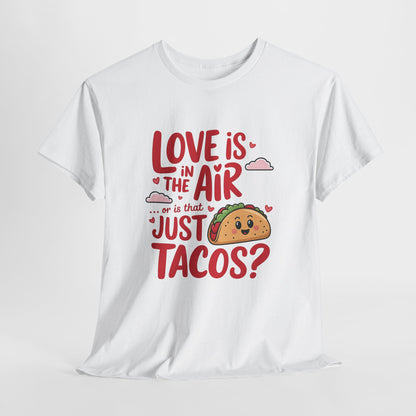 Hanging white T-shirt featuring red and black text with a taco illustration that reads "Love Is In The Air Or Is It Just Tacos?" Exclusive release for Valentine’s Day. Part of the Vivid Divergence Sensory Friendly Unisex Tees Range.