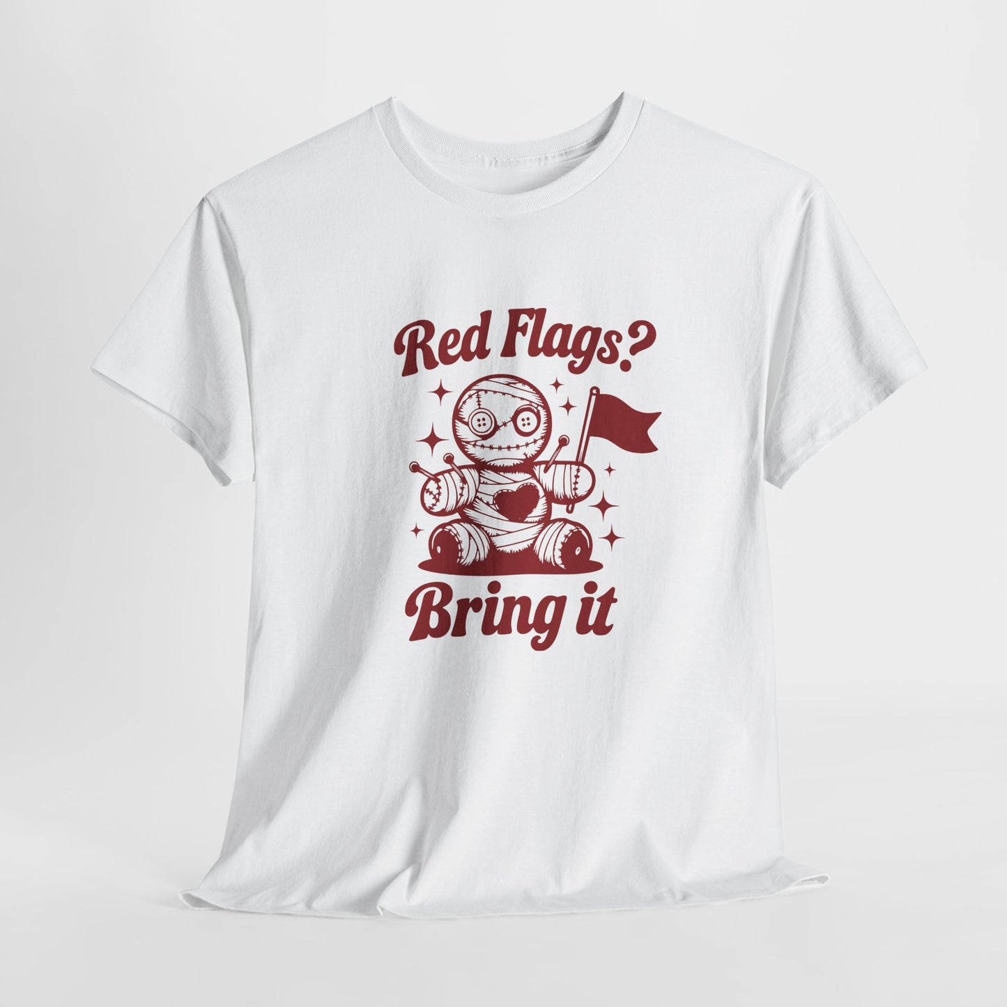 Hanging view of a white T-shirt with "Red Flags? Bring It" text and a cute voodoo doll holding a red flag surrounded by sparkles. Part of the Vivid Divergence Sensory Friendly Unisex Tees Range.