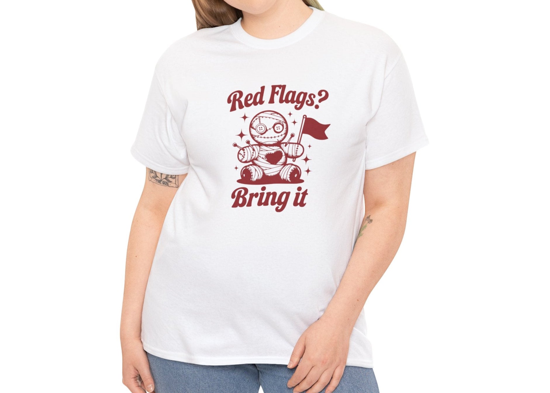 Modeled view of a white T-shirt with "Red Flags? Bring It" text and a cute voodoo doll holding a red flag surrounded by sparkles. Part of the Vivid Divergence Sensory Friendly Unisex Tees Range.