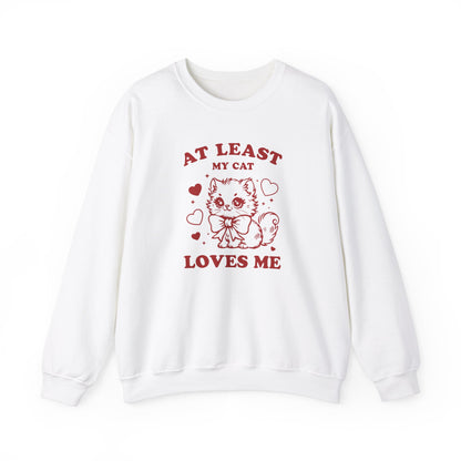 Front view of a white sweatshirt with "At Least My Cat Loves Me" text and cartoon cat design in red. Part of the Vivid Divergence Sensory Friendly Sweaters Range.